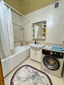 y baño con lavadora y lavamanos. en Квартира, en Prigorodnyy