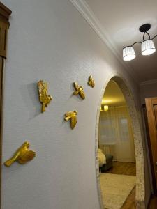una pared con adornos de oro en una pared con espejo en Квартира, en Prigorodnyy