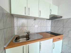 a kitchen with white cabinets and a sink at Apartments Marija Magdalena in Hvar +37 photos