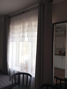 una ventana con una cortina blanca en una habitación en Noclegi, pokoje, kwatery "Nad Bzurą", en Łowicz