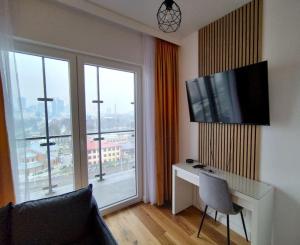 een woonkamer met een bureau en een groot raam bij Wola 940 in Warschau