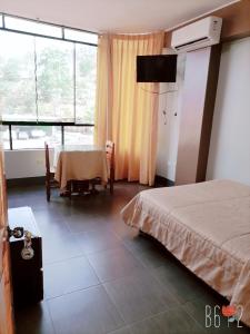 sypialnia z łóżkiem, stołem i oknem w obiekcie Confort Pichanaki w mieście Pichanaki