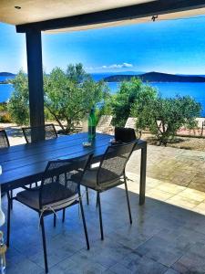 a blue table and chairs on a patio with a view of the water at Holiday Home Bepo in Sevid