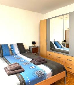 1 dormitorio con 1 cama grande y toallas. en Studio Anémones, meublé, équipé, Monthey, en Monthey