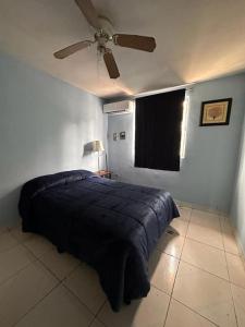 - une chambre avec un lit et un ventilateur de plafond dans l'établissement Casa cómoda y bonita, à Monterrey
