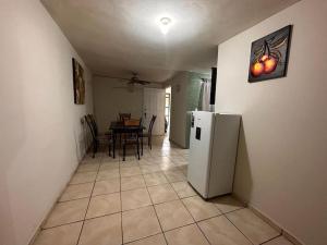 a kitchen and dining room with a white refrigerator at Casa cómoda y bonita in Monterrey