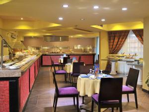 艾因蘇赫納的住宿－Porto South Beach by Amer Group - Families only，餐厅设有桌子、紫色椅子和柜台