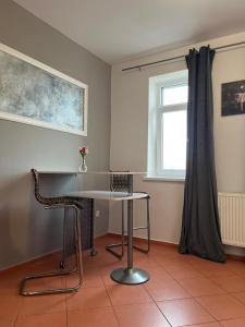 une table et une chaise dans une pièce avec une fenêtre dans l'établissement 4 May Plaza, à Bratislava