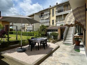 a patio with a table and chairs and an umbrella at Casa Angioletta in Gassino Torinese