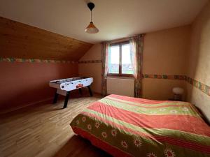 a bedroom with a bed and a table in it at La maison de Louise in Bians-les-Usiers