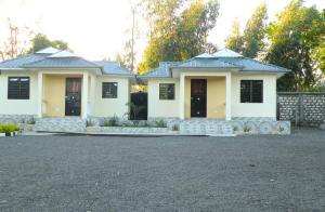 ein weißes Haus mit schwarzen Fenstern und einer Auffahrt in der Unterkunft Wajiji Homes in Mtwapa