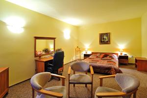 a bedroom with a bed and a desk and two chairs at Hotel Restauracja Twist in Krosno