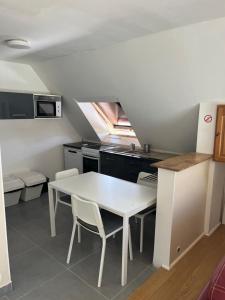 a kitchen with a white table and chairs in a room at Chambre privée 1-2 coatodon in Guipavas