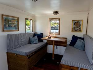 um pequeno quarto com dois bancos e uma mesa em Unique Boat Accomodation - Bornholm - Fjælstavn em Hasle