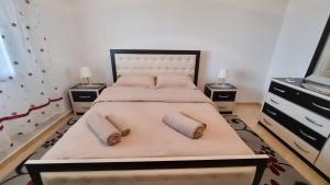 una camera da letto con un grande letto con due comodini di Vila Dean a Berat