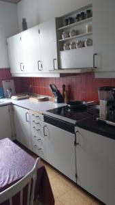 a kitchen with white cabinets and a black counter top at White house 51 in Horsens
