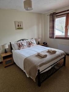 a bedroom with a bed with two pillows on it at Wilmar Lodge in Arrochar