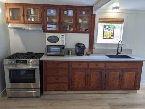 a kitchen with wooden cabinets and a stove top oven at Surfmen's Cottage - Historic Coast Guard property in Point Arena +8 photos