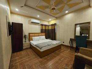 um quarto com uma cama e uma televisão em Hotel Gulberg inn em Lahore