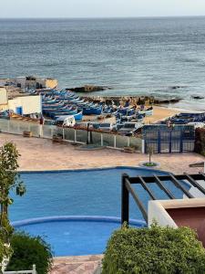 a beach with blue chairs and the ocean at résidence les meridiennes tiguert in Agadir