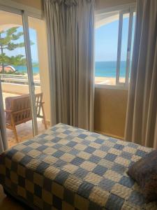 a bedroom with a bed and a view of the beach at résidence les meridiennes tiguert in Agadir