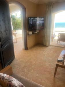 a living room with a flat screen tv and a couch at résidence les meridiennes tiguert in Agadir +12 photos