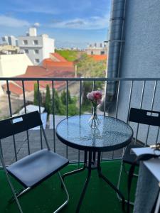 une table en verre avec un vase de fleurs sur le balcon dans l'établissement 4 May Plaza, à Bratislava 12 autres photos