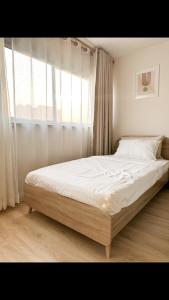 a bed in a bedroom with a large window at OP Open View เมืองทอง T12 impact muang thong thani in Ban Bang Phang