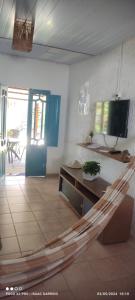 a living room with a hammock in a room with a tv at Casas 1 de Isaac in Maragogi