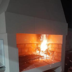 a brick fireplace with a fire in it at La Ruperta in Mercedes