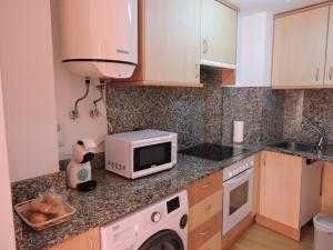 a kitchen with a microwave and a washer at Apartamento casco histórico de Calatayud in Calatayud