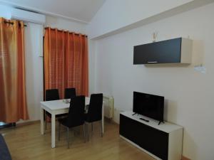 comedor con mesa y TV en la pared en Apartamento casco histórico de Calatayud, en Calatayud