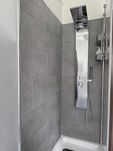 y baño con ducha de azulejos grises. en Rossini apartment, en Sassoferrato