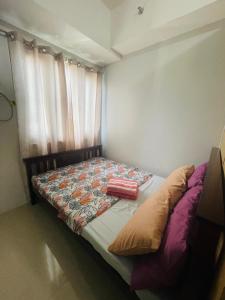 małe łóżko w sypialni z zasłoną w obiekcie The Grass Residences w mieście Manila