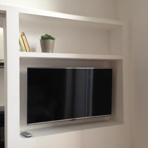 einen Flachbild-TV in einer weißen Wand in der Unterkunft Appartamentino Vittorio Emanuele in Bari