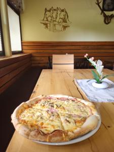 a pizza sitting on top of a wooden table at Rooms MARETČ in Bohinj +14 photos