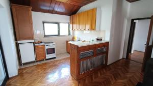 a kitchen with wooden cabinets and a counter top at Guesthouse Trikic in Drvar