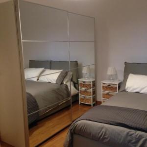 a bedroom with two beds and a mirror at Appartamentino Vittorio Emanuele in Bari