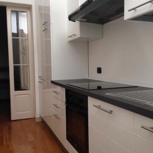 a kitchen with white cabinets and a black counter top at Appartamentino Vittorio Emanuele in Bari