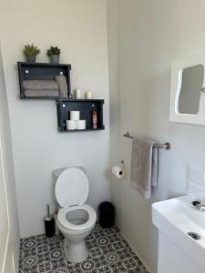 a white bathroom with a toilet and a sink at Protea Loft - Romantic stay - No Load shedding in Hilton