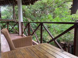 porche con mesa de madera, sillas y árboles en PASA LODGE ZANZIBAR en Nungwi