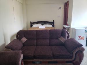 kanapa przed łóżkiem w pokoju w obiekcie Sunset suite w mieście Meru
