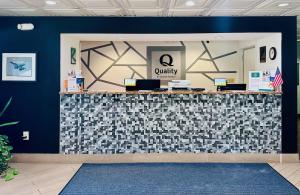 a lobby with a check in counter with a blue wall at Quality Inn At Eglin AFB in Niceville