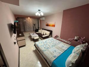 a bedroom with a bed and a living room at Партерно Студио in Ahtopol