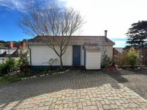 a small white house with a tree in front of it at Boathouse Cottage (Historic Coast Guard property) in Point Arena +9 photos
