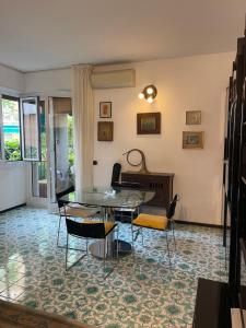 sala de estar con mesa de cristal y piano en Casa Basilico Camogli, en Camogli