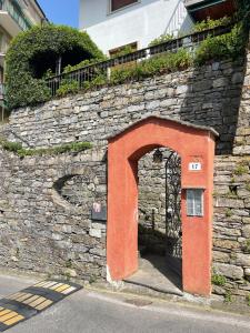 una entrada a una pared de piedra con una puerta naranja en Casa Basilico Camogli, en Camogli