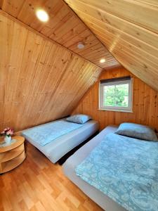 twee bedden in een kamer met houten wanden bij Ferienhuette in Altfriesack