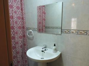 y baño con lavabo y espejo. en Duplex casco historico en Calatayud