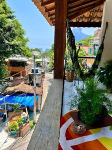 uma varanda com rede de descanso e algumas plantas em House TT do Vidigal no Rio de Janeiro